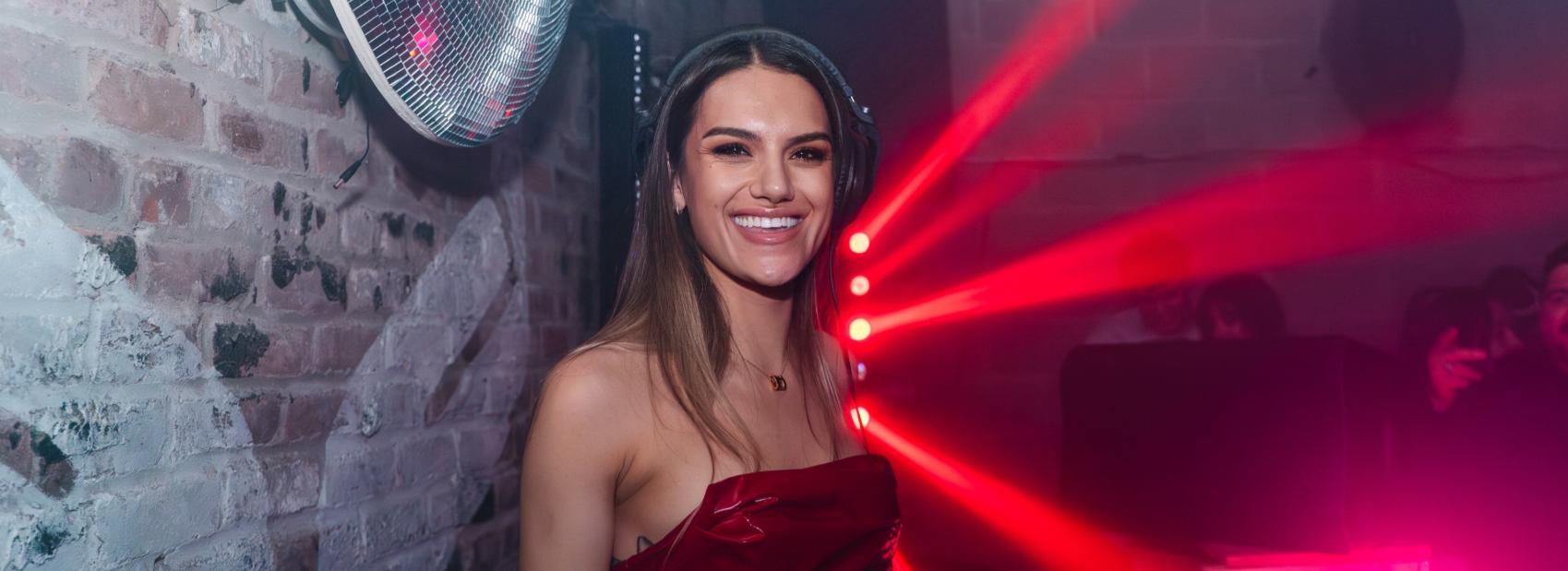 Sierra Bomba DJing in a red-lit New York club